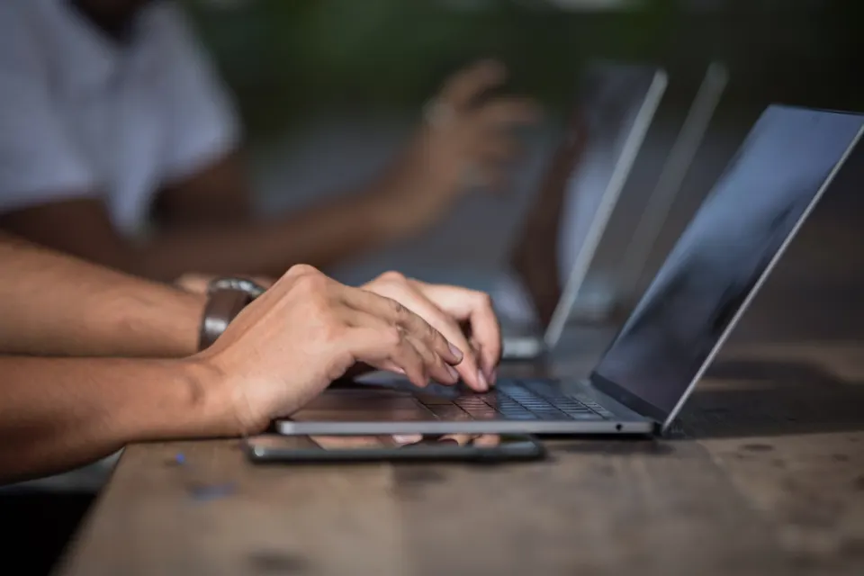 Hands typing on a laptop during website planning
